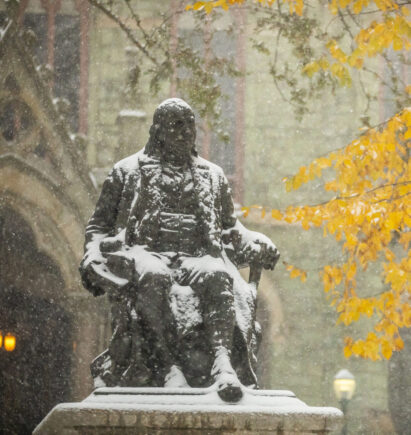 Ben Franklin statue covered in snow in front of College Hall