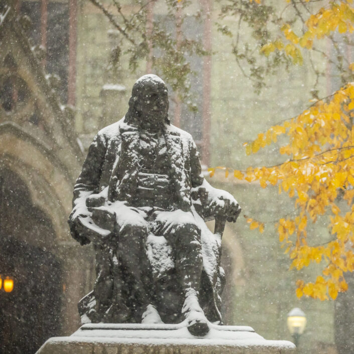 Ben Franklin statue covered in snow in front of College Hall