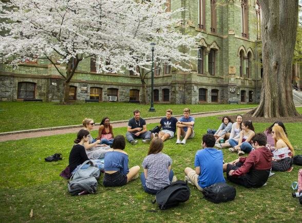 Students sitting in a circle in fronr of College Hall